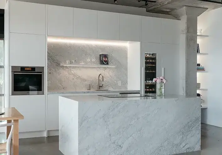 White quartz countertop installed over modern white slab kitchen cabinets