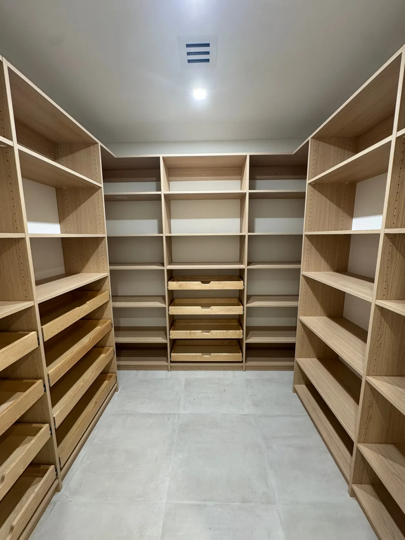 Custom oak walk-in pantry shelving with adjustable storage zones